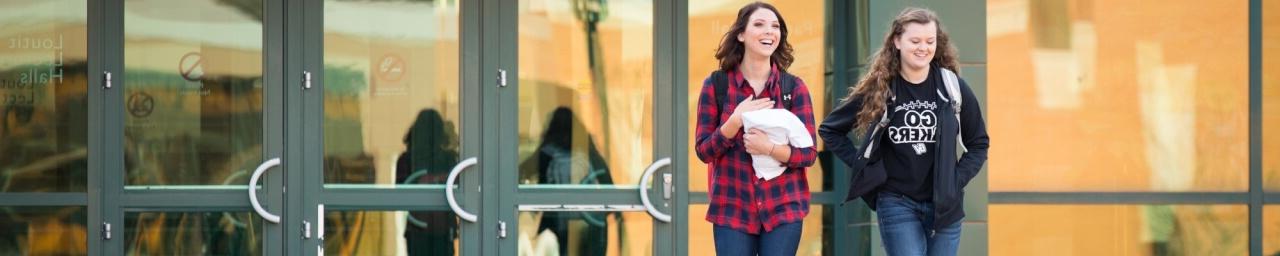 Two students walking outside of the Student Services building